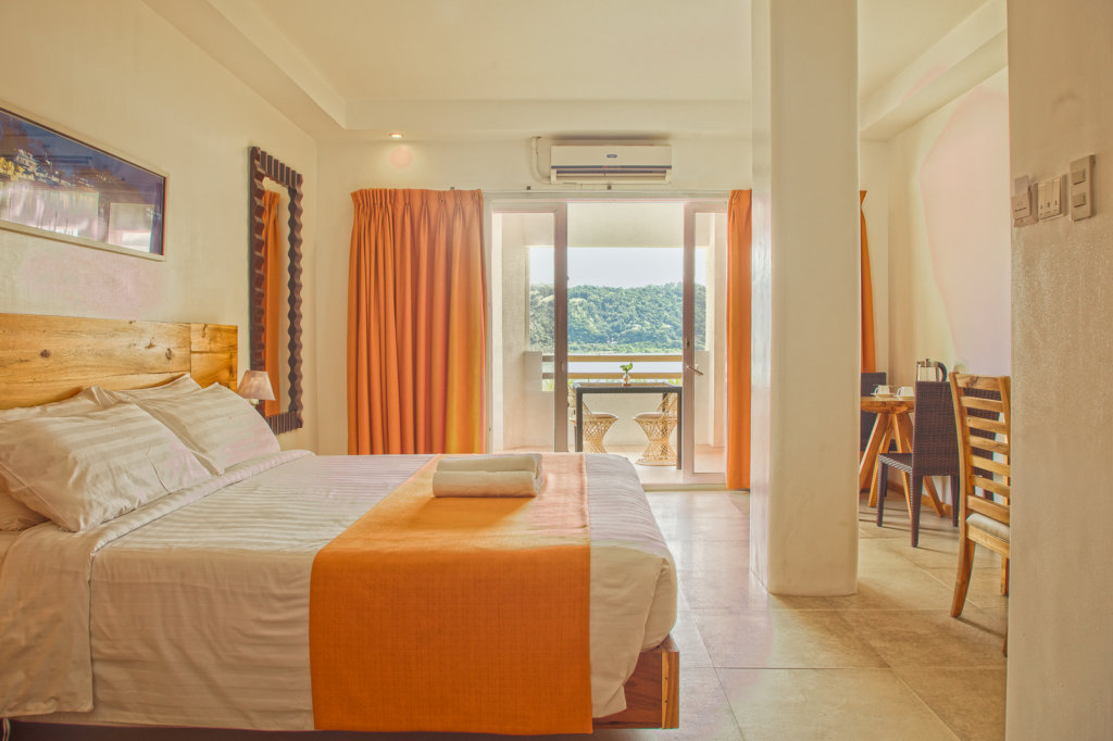 Enjoy the sea breeze through this room's semi-private balcony that overlooks the pool and cliffside of the property. Perfect for two, with amenities that bring delight to any occasion.